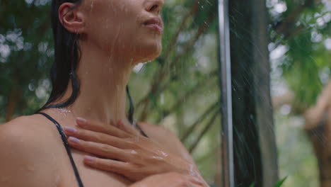 attractive woman in shower wearing bikini washing body cleansing skin with refreshing water enjoying natural beauty spa showering outdoors in nature