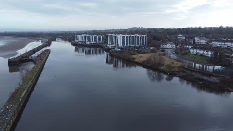 early morning aerial view riverside waterfront contemporary apartment office buildings canal regeneration real estate descending dolly right