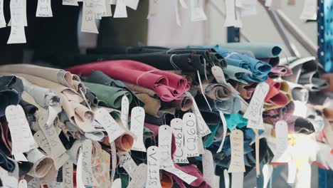 colorful leather samples with tags in a shoe factory storage area