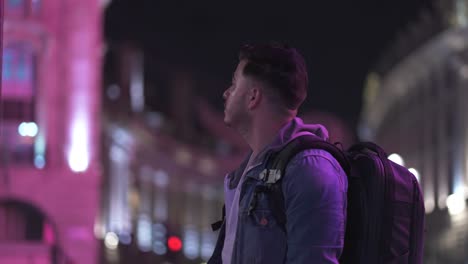 low light portrait shot of man looking at london sights with bus passing by