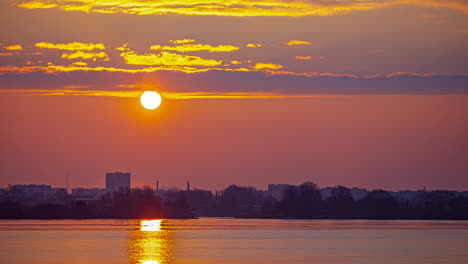 sun rising timelapse over coastal city, rays reflecting on water surface