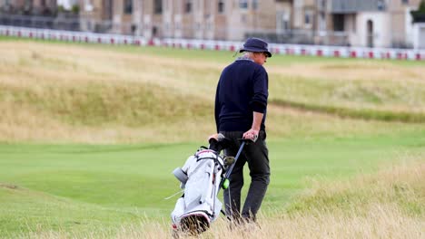 golfer walking with bag on st andrews course