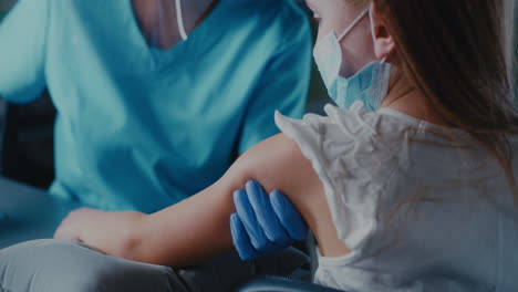 child receiving a vaccination from a healthcare professional