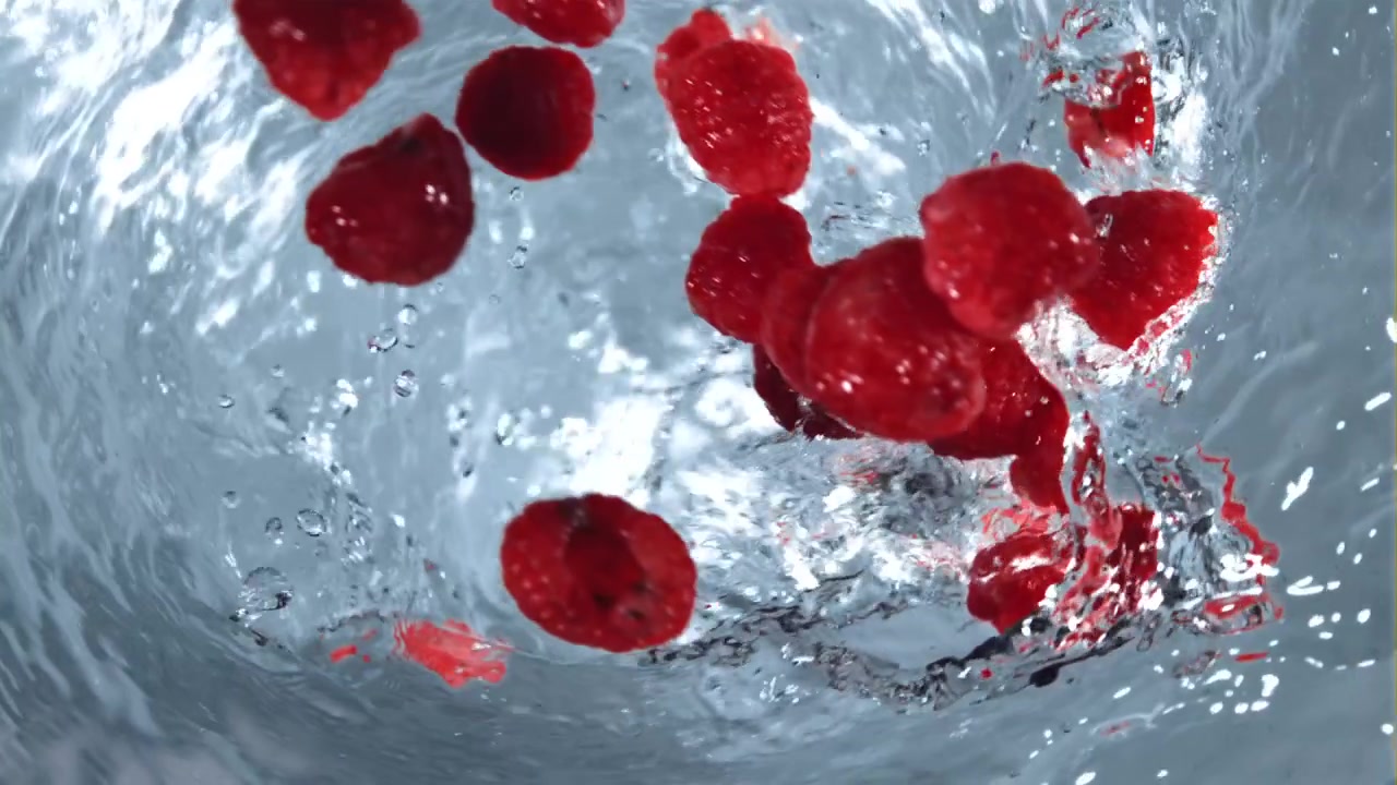 Red Raspberries Falling into a Swirling Water Vortex in Slow Motion