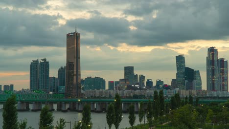 Puente-Ferroviario-Del-Río-Han-Sobre-El-Río-Han-Con-Rascacielos-De-La-Isla-Yeouido-Y-Edificios-De-Gran-Altura-Al-Atardecer-En-Seúl,-Corea-Del-Sur