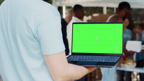 man with laptop showing green screen