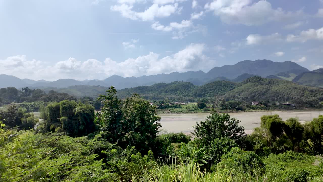 Montagne verdi e vegetazione tropicale lussureggiante che circondano il tranquillo fiume Nam Song in Laos