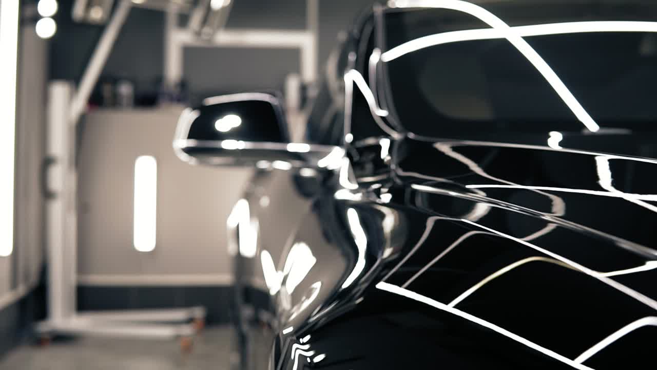 화려한 불빛이 켜진 오토센터에서 온 멋진 검은색 새로운 차입니다.