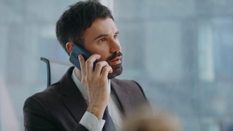 business man answering call at modern workplace close up. man discussing problem