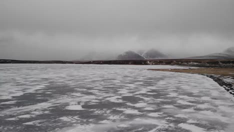 Aerial-dron-shot-of-frozen-lake-during-cold-winter-time-in-iceland-highlands