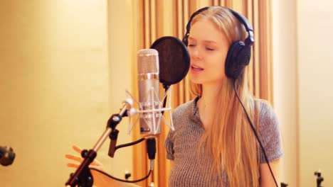 mujer cantando en un estudio de grabación