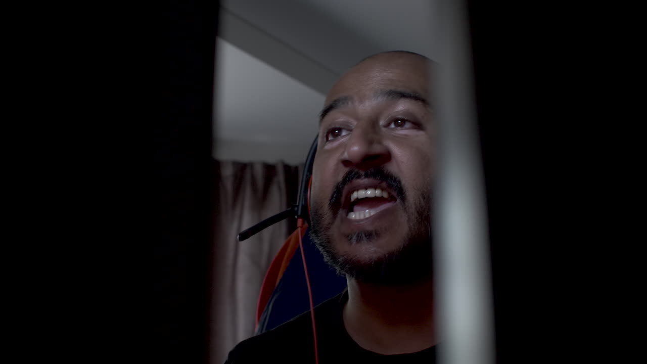 hombre indio calvo con auriculares golpeando la cabeza de un lado a otro escuchando música y respondiendo llamadas