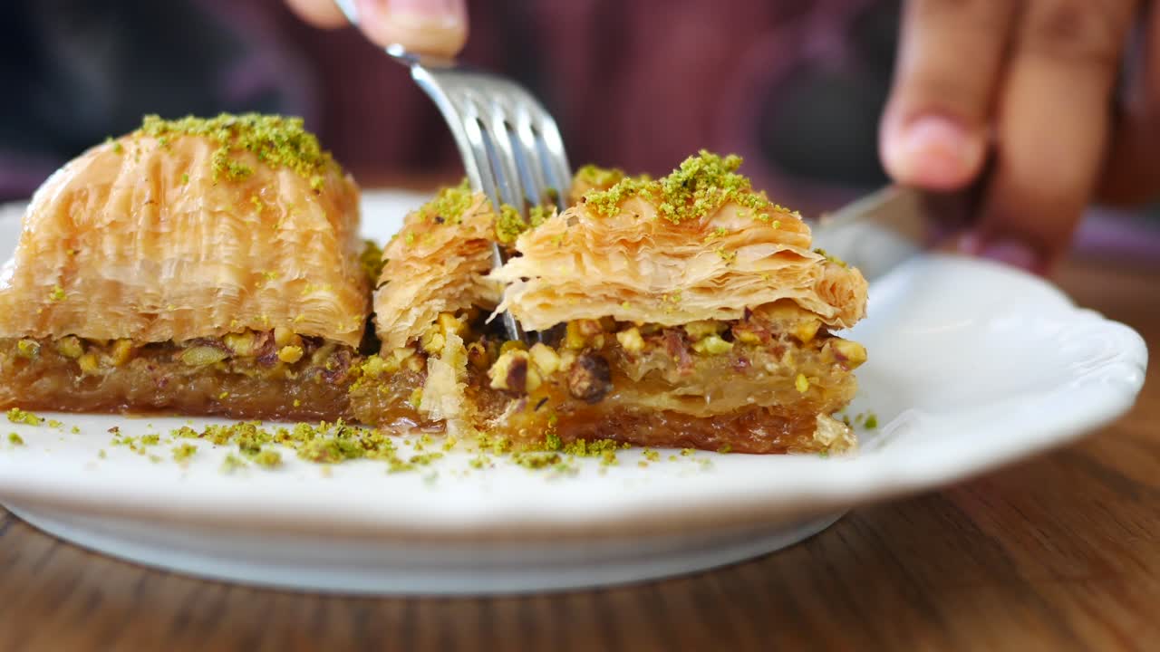 Çatalla baklava yiyen bir kişi