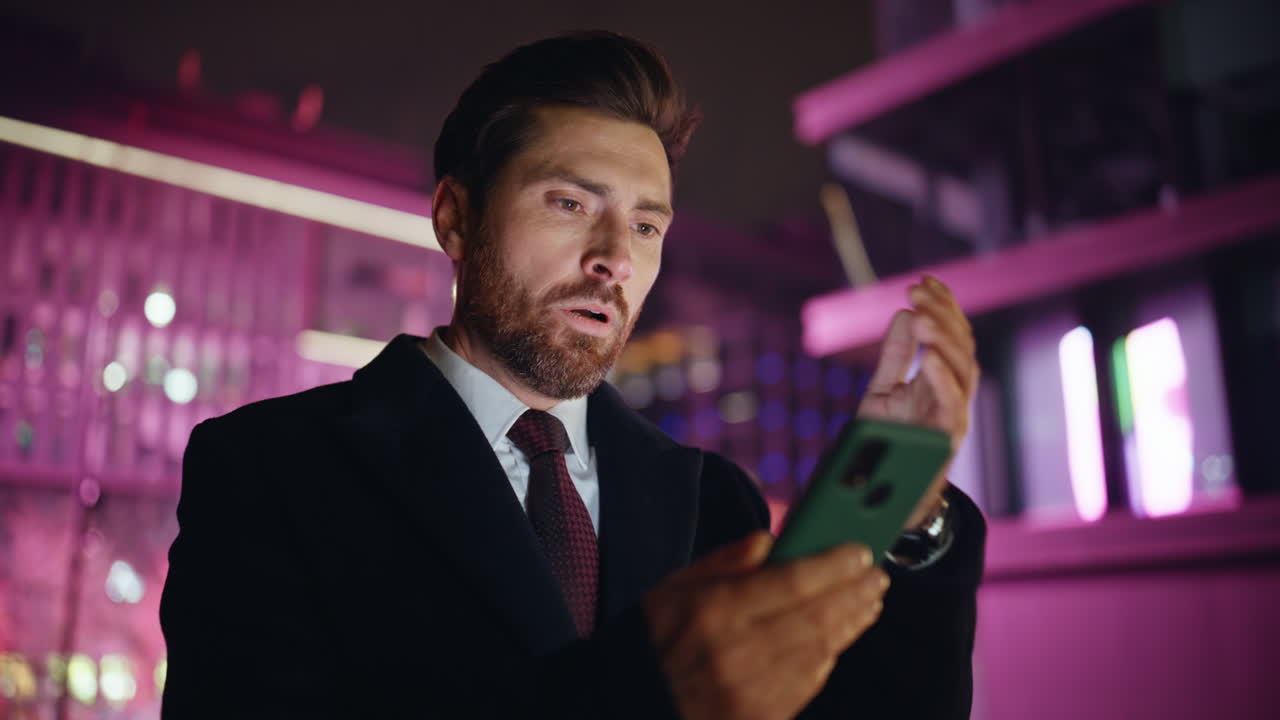 Night manager fingers messaging mobile phone at late city light street closeup