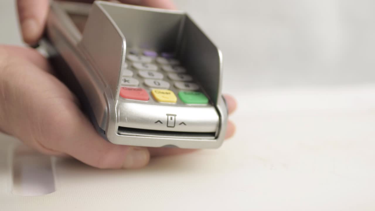 Hand presenting pdq payment machine to buy goods close up shot