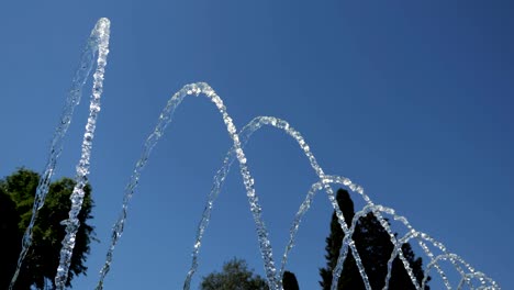 fountain with water jets falling on center in city park at summer day.