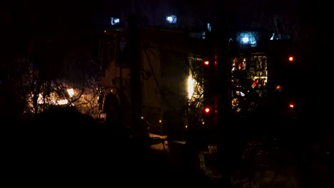 firetruck with lights on and firefighters at night