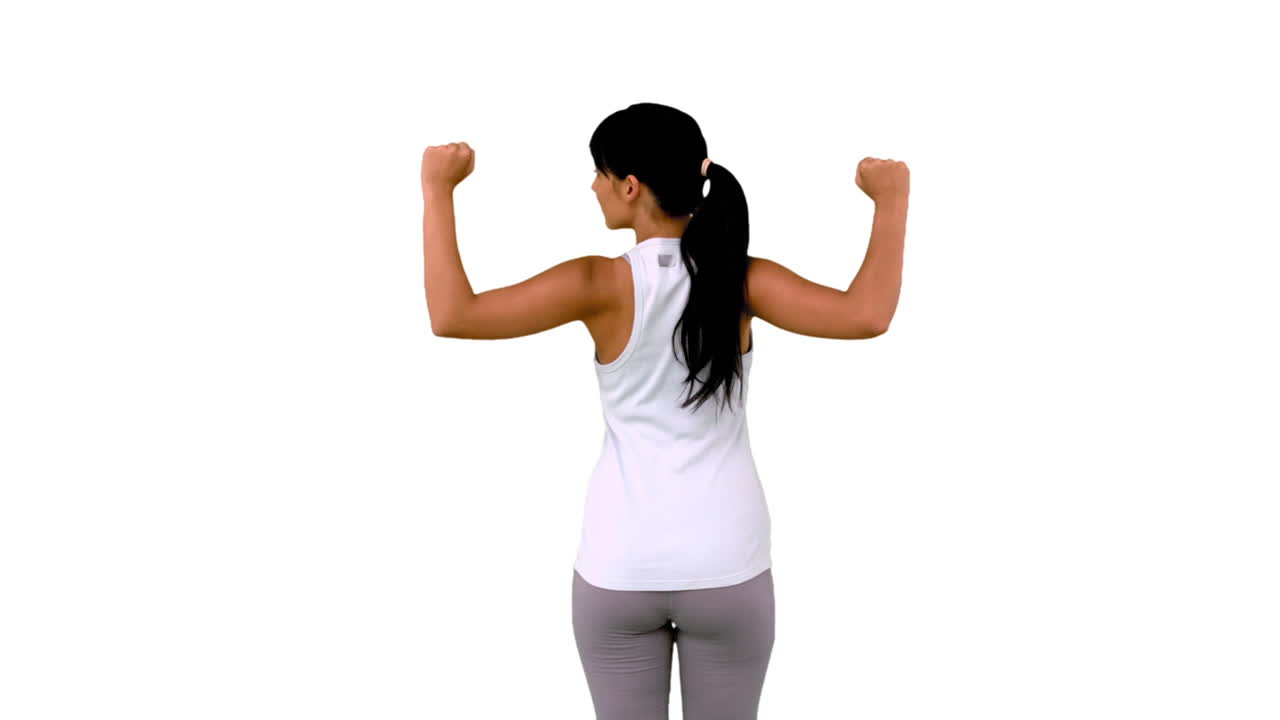 mujer en forma tensando los músculos del brazo vista trasera
