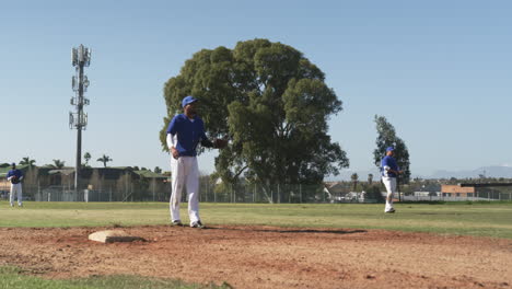 playing baseball, pitcher on mound preparing to throw ball, teammates in field