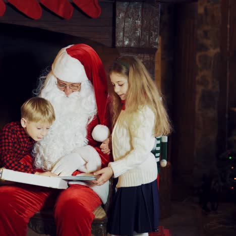 santa claus is showing an album with photos to kids on the background of a fireplace with christmas socks and with a christmas tree in the room, but the boy in a plaid shirt runs away.