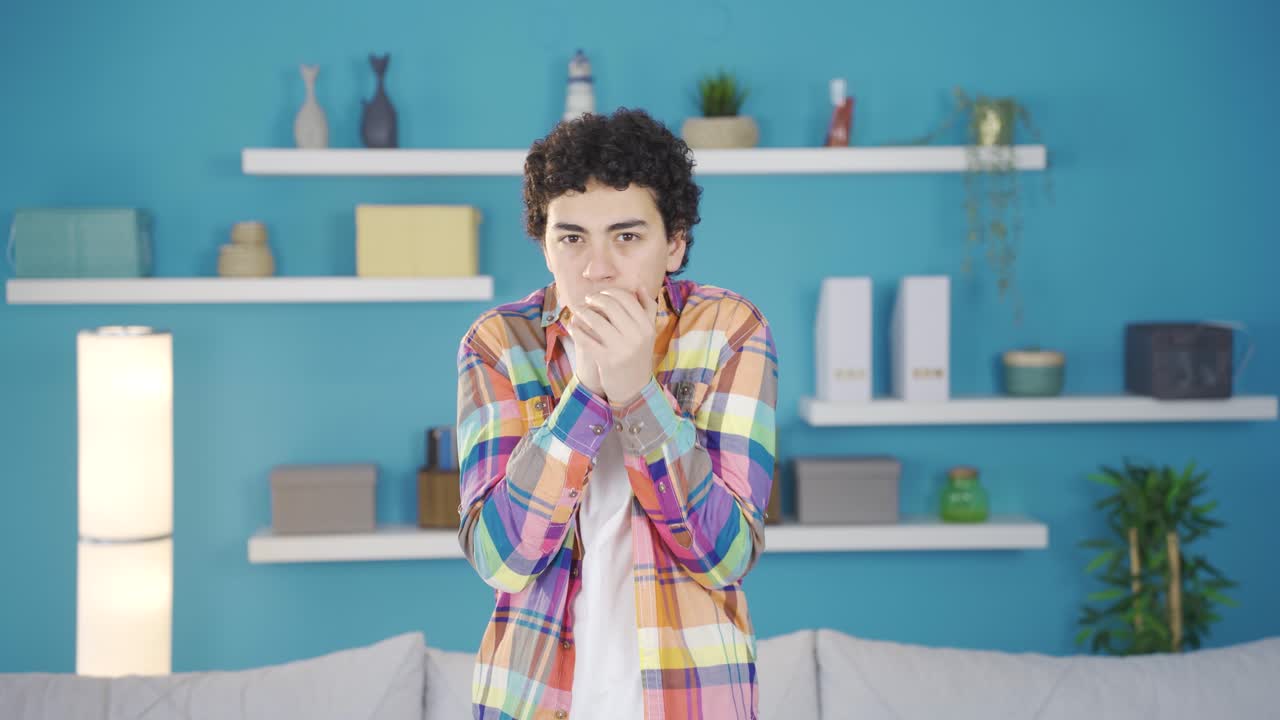 Ragazzo che ha freddo a casa e guarda la telecamera