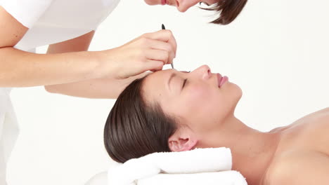 woman getting her eyebrows shaped