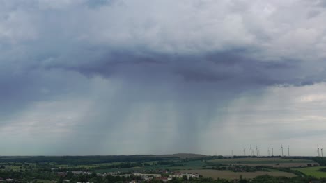 a thunderstorm is brewing in the sky over wide green fields