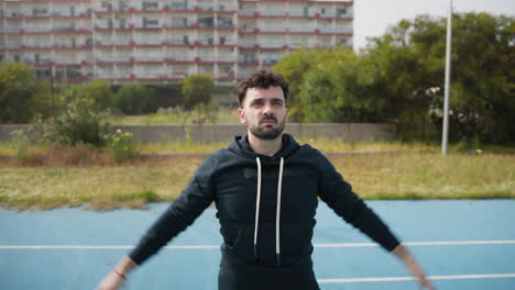 man does breathing exercises before the basketball game in the park