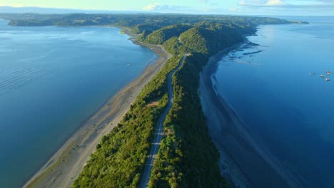 Aerial-view-following-a-esker-road-in-middle-of-water-and-beaches-of-Chiloe,-Chile