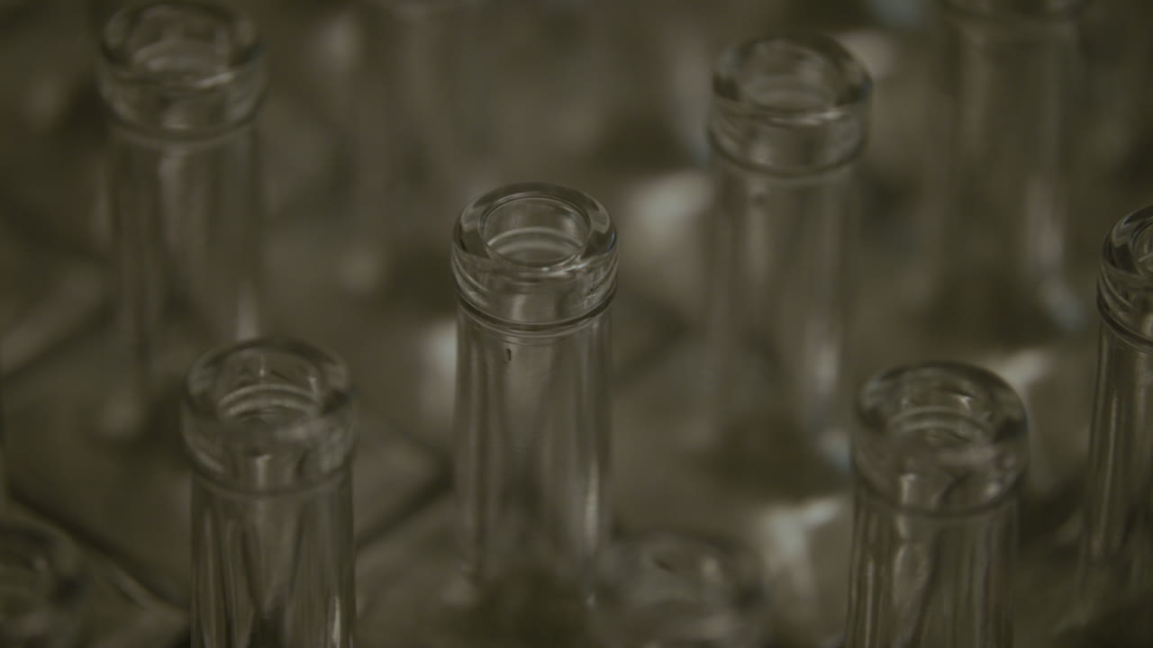 유리 주류 병 목의 패닝 샷을 닫습니다