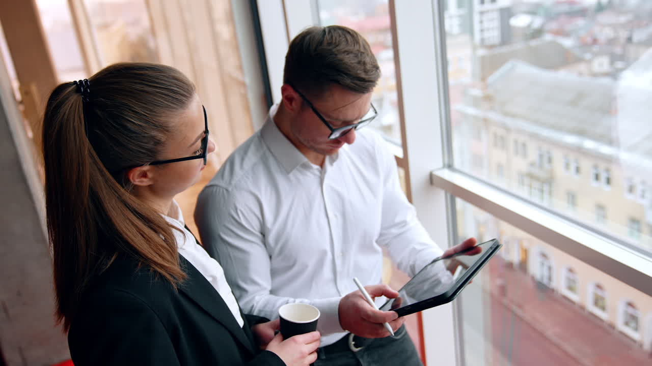 Communication and cooperation in the office work. Colleagues look at I-pad and then on camera. Top view.