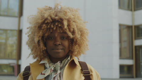 portrait of a smiling young woman with curly blonde hair