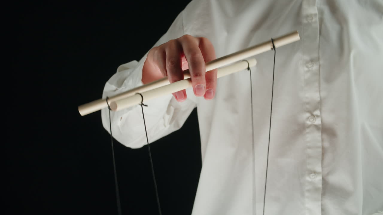 Close-up of Hand Manipulating Marionette Puppet Control Bar