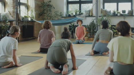 women practicing hero pose on yoga class
