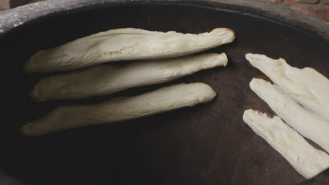 Closeup-View-Of-Raw-Shoti-Bread-Dough-Sticking-On-The-Hot-Surface-Of-Rustic-Round-Clay-Oven-In-Sighnaghi,-Kakheti,-Georgia