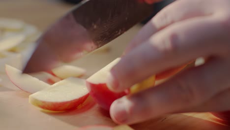 Man-Precisely-Slicing-an-Apple-on-a-Wooden-Cutting-Board