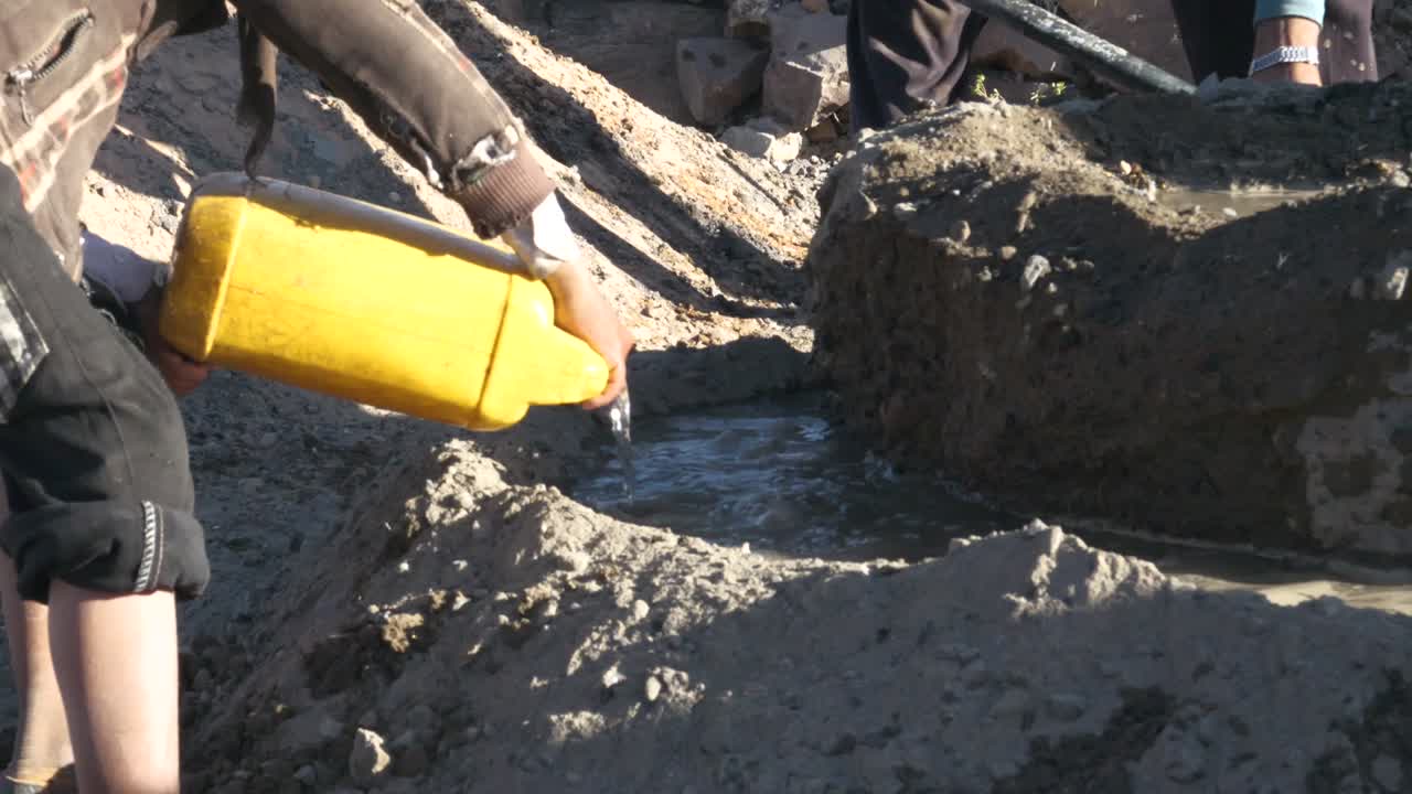 mientras el constructor trabaja, vierten agua para mezclar cemento a la antigua