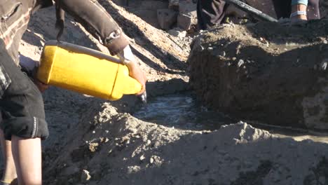 while builder working they pouring water to mix cement old fashion