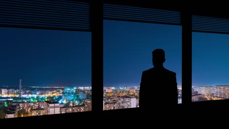 the businessman working on a virtual display on the night urban background