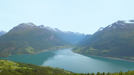 Paisaje-Pacífico-Del-Lago-Y-Montañas-Verdes-En-Rakssetra,-Loen,-Noruega---Retroceso-Aéreo