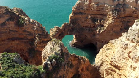 arco de piedra de formación rocosa &quot;catedral&quot; en ponta da piedade lagos algarve - punto de interés aéreo vista superior de órbita lenta