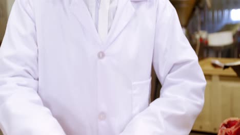 female butcher arranging raw meat in a tray