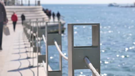 coastal walkway with metal railing and people