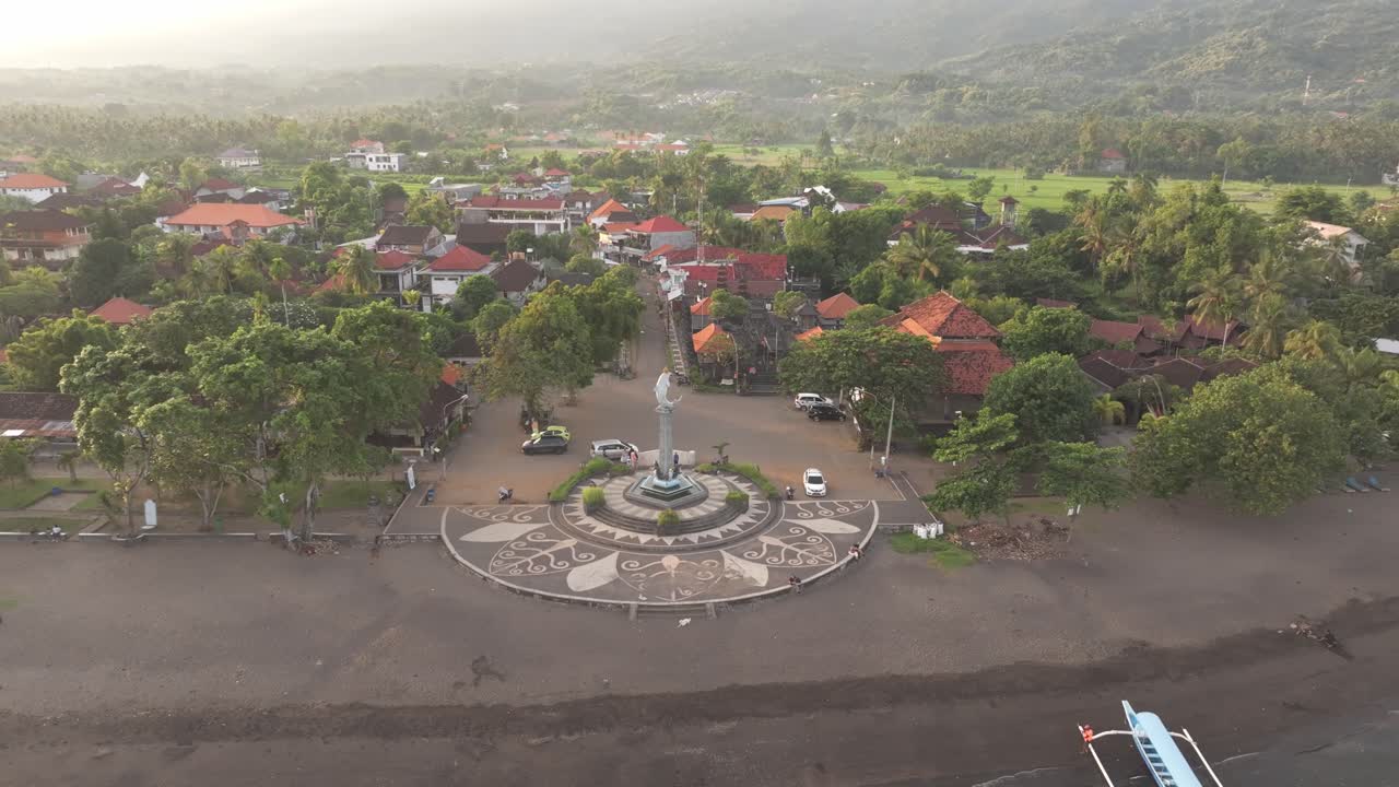 Fajar di atas air tenang dan tepi desa di Bali Utara, Indonesia