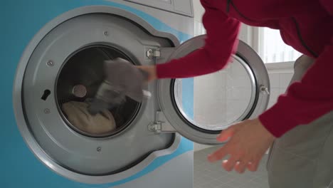 hombre cargando una lavadora con toallas