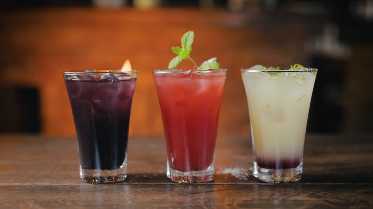 Glasses of Cocktails on a bar, Finishing, Mixing in Slow Motion