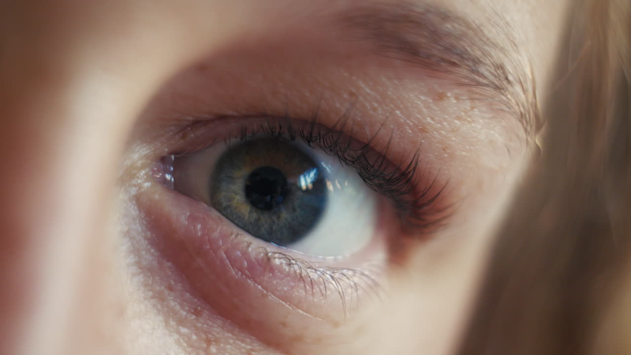 신선하고 경각심이 넘치는 표정으로 눈을 뜨는 여자의 클로즈업