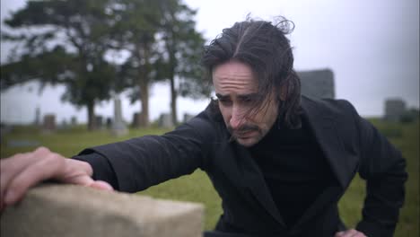 sad, emotional man saying goodbye to loved on at grave tombstone