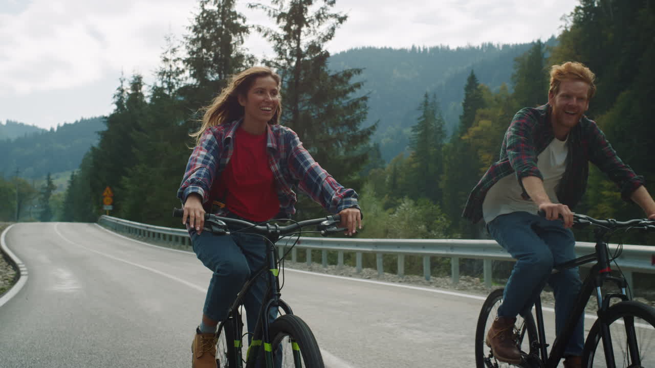 산에서 자전거 타기를 즐기는 커플. 숲 고속도로에서 운동하는 자전거 타는 사람들.