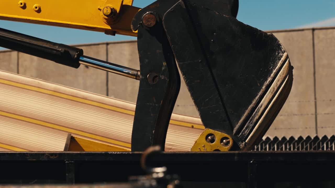 cubo de la excavadora sobre la valla de enlace de cadena